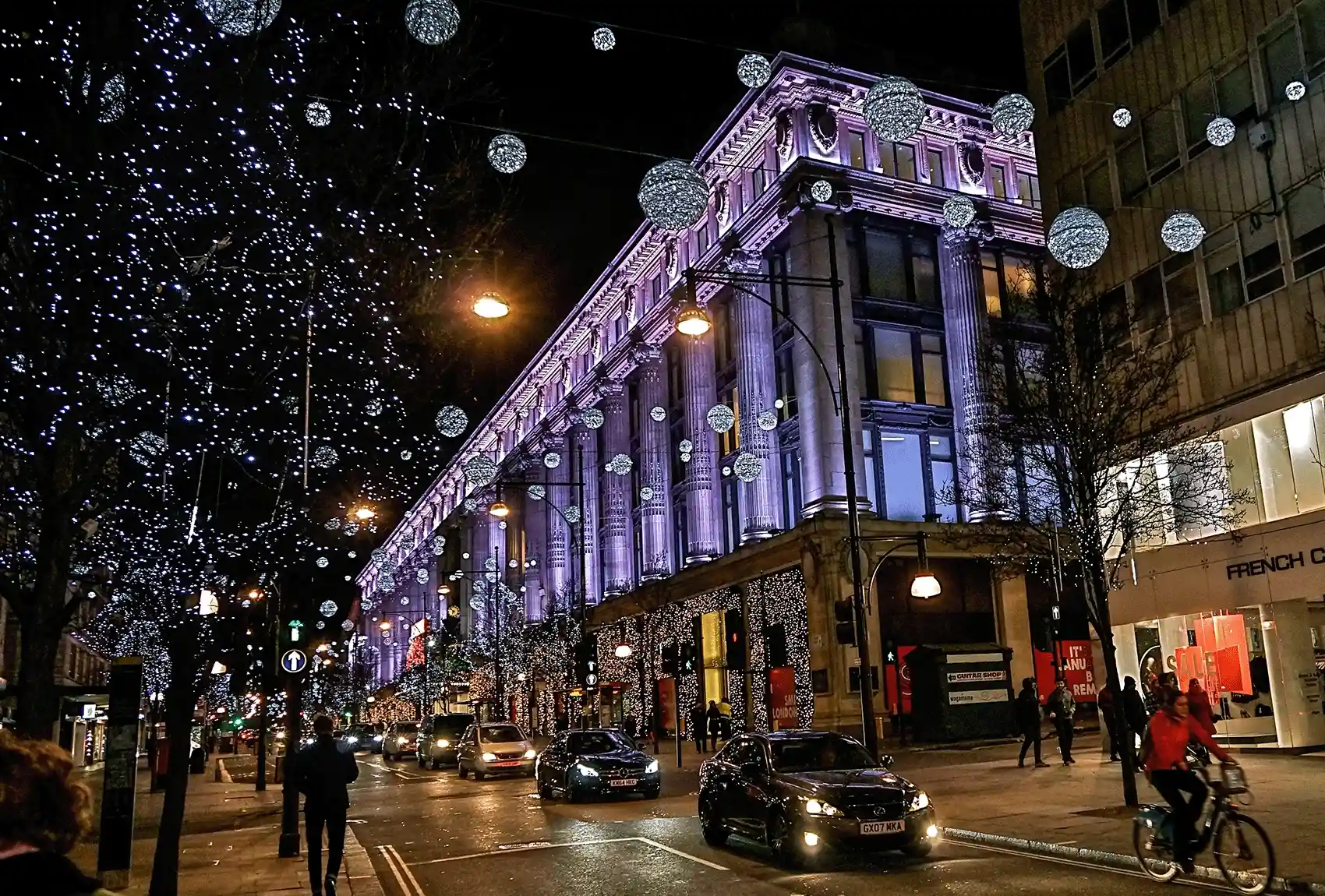 Take a stroll throughout London's exquisitely lit streets, which are alive with glittering Christmas lights that make the city come to life during the holiday season. London streets and buildings are illuminated with Christmas lights at night.