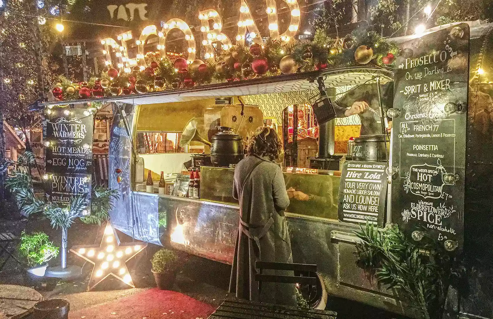 A woman buying a drink at a trailer during the Christmas season in London.