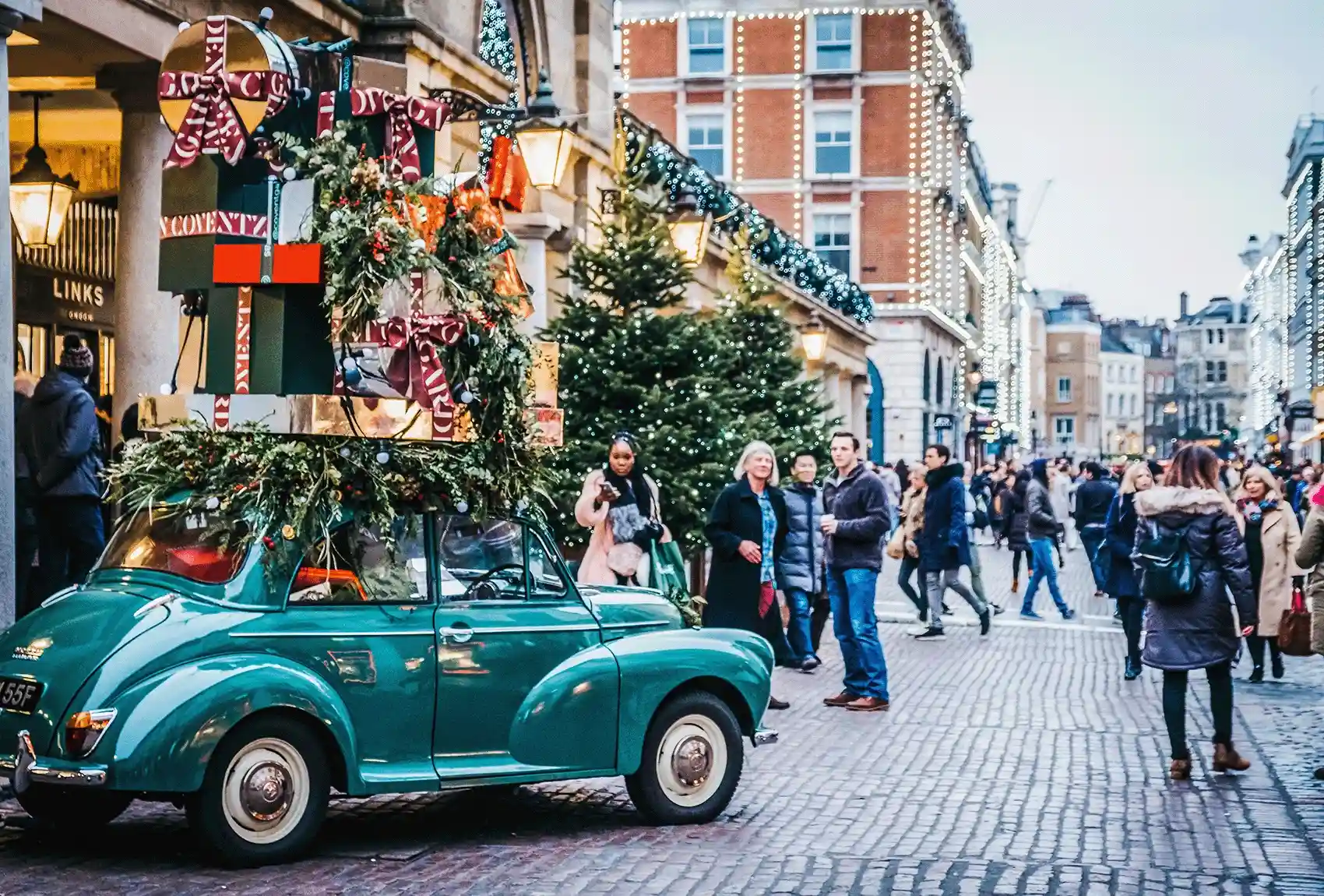 A festively decorated car with Christmas presents in Covent Garden, London, during the Christmas season, where many people go shopping. The Covent Garden car is decorated for Christmas with presents.