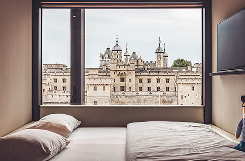 Inside CitizenM Hotel London with a stunning view of the historical Tower of London. CitizenM Hotel London offering stunning view of Tower of London from one of the hotel rooms.
