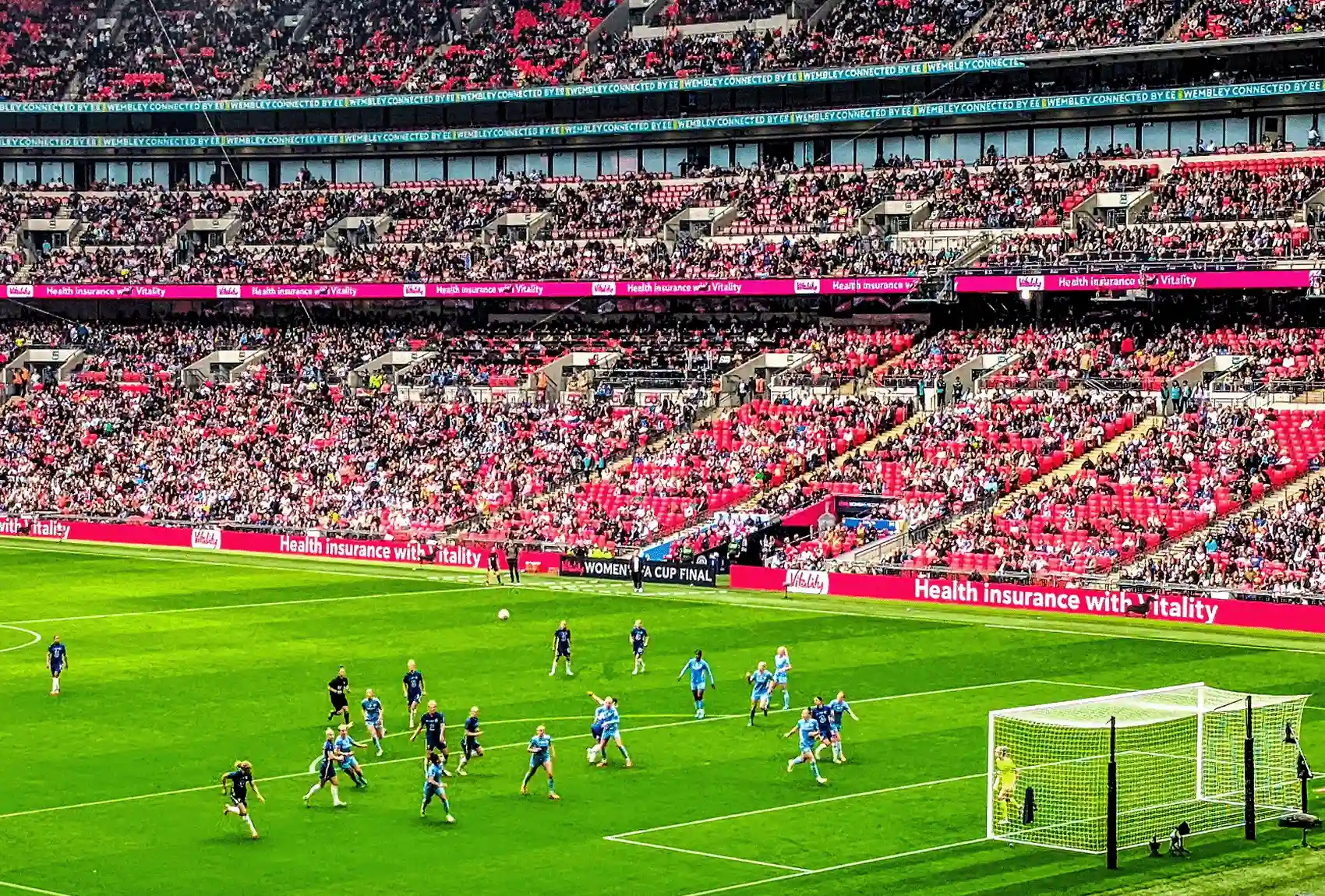 A football match at Wembley Stadium with fans filling the seats.