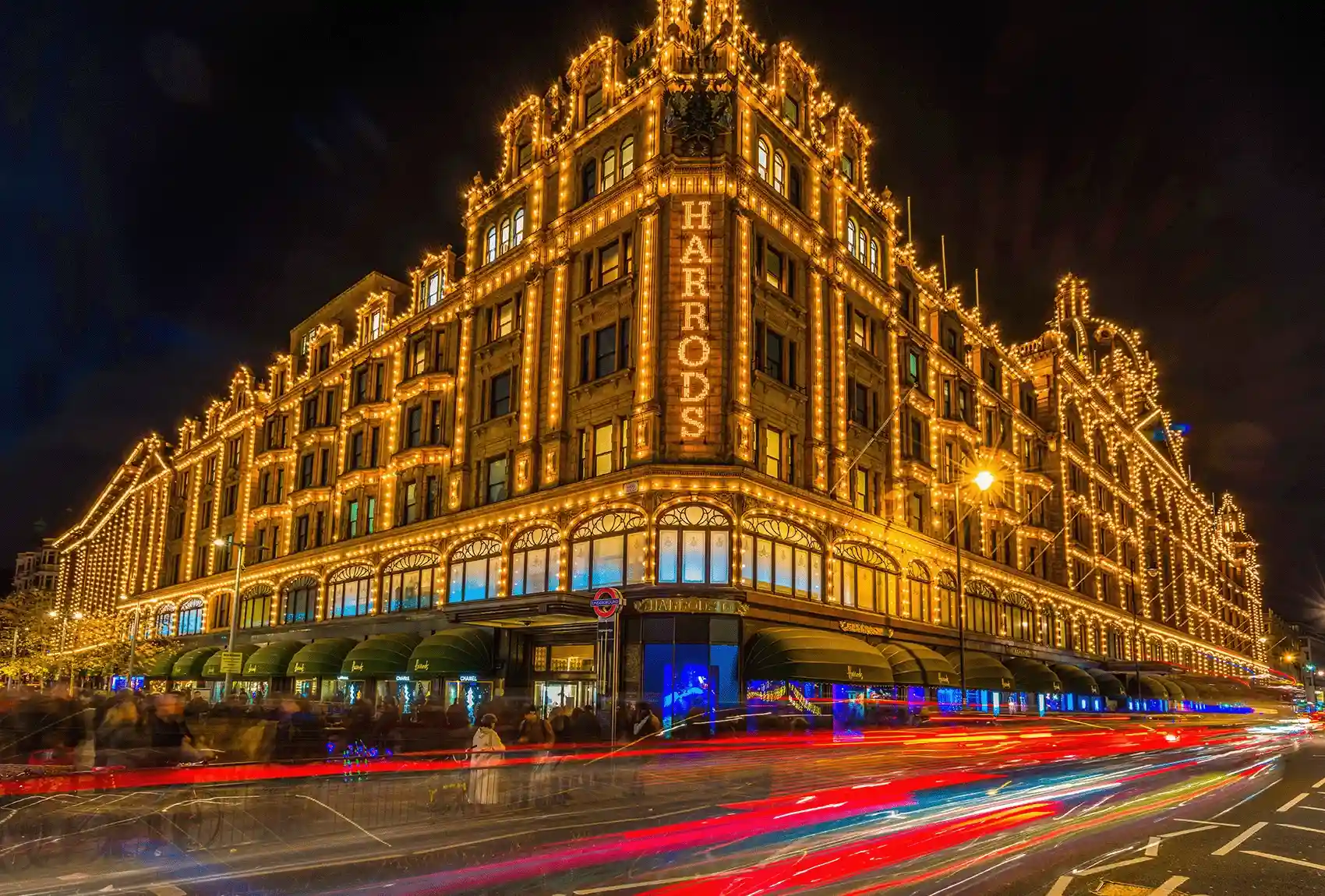 London's Harrods department store is illuminated with golden lights during the Christmas shopping season. London's Harrods lit up with golden lights during Christmas, attracting shoppers.