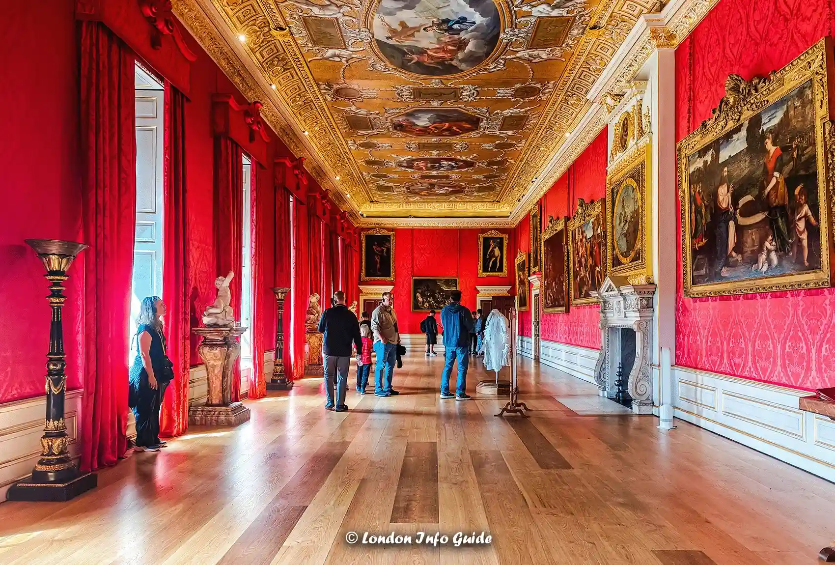 The Red-draped gallery lined with portraits and bathed in natural light.