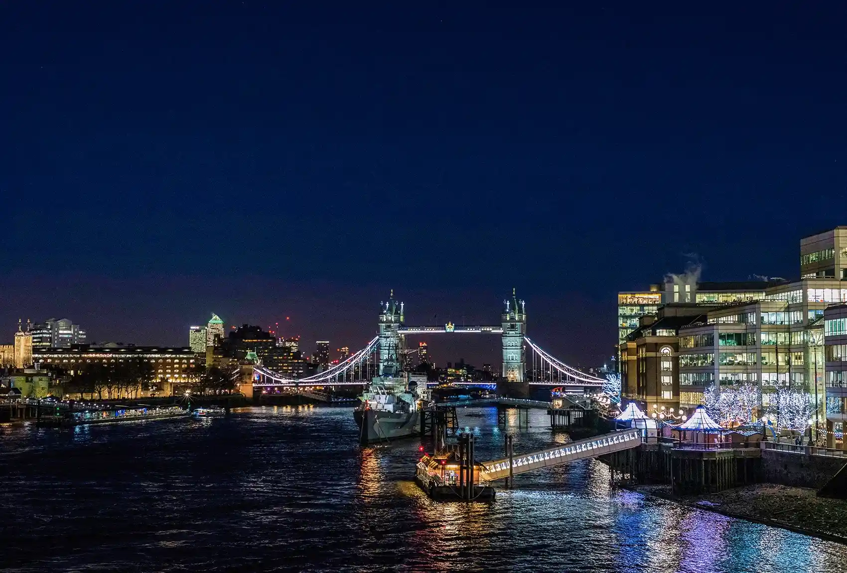 Tower Bridge and festive lights reflecting on the River Thames. Tower Bridge at Christmas lit up.