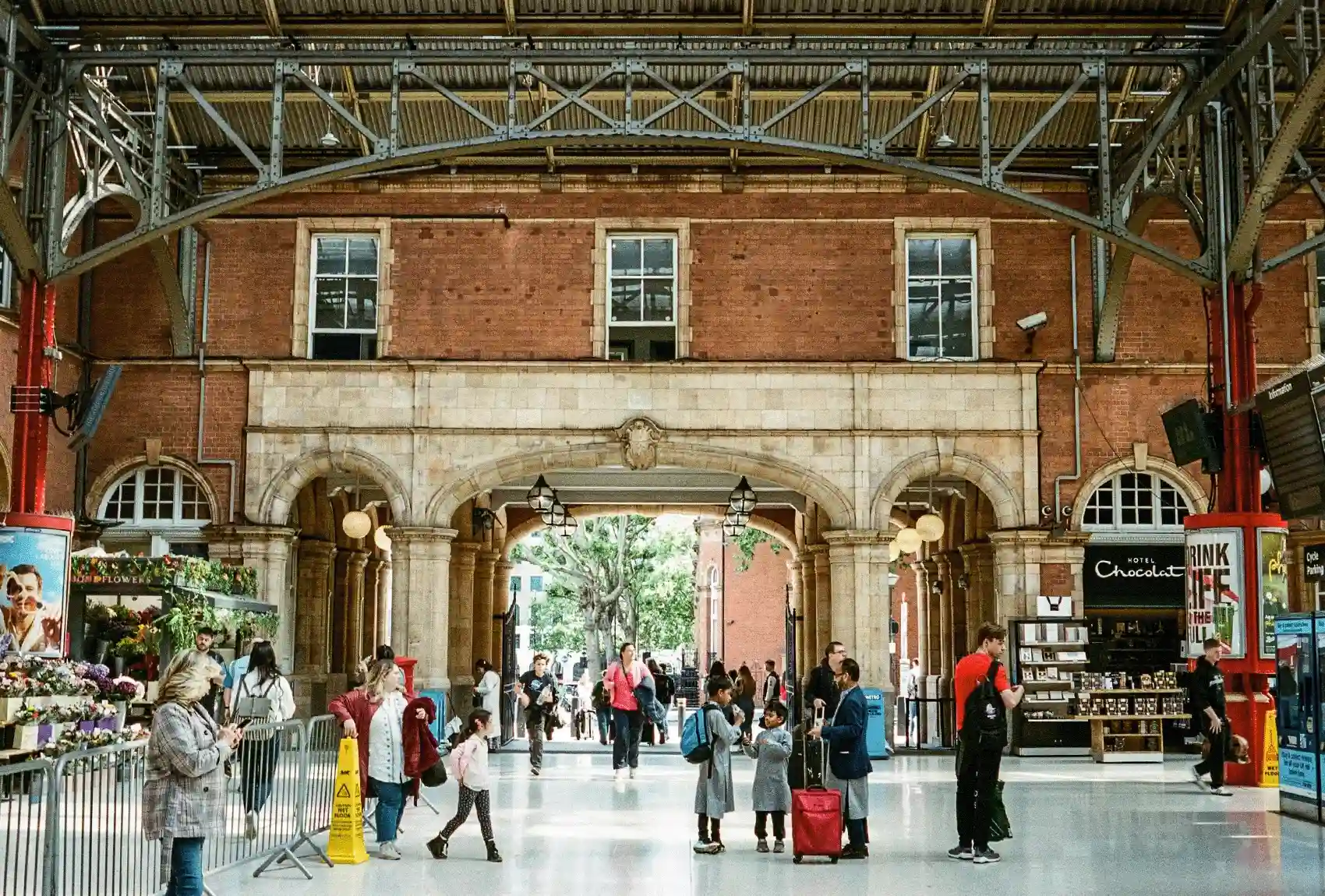 Victoria Train Station, one of London’s busiest transportation hubs, is alive with travelers coming and going. Busy Interior of Victoria Train Station with Travelers.