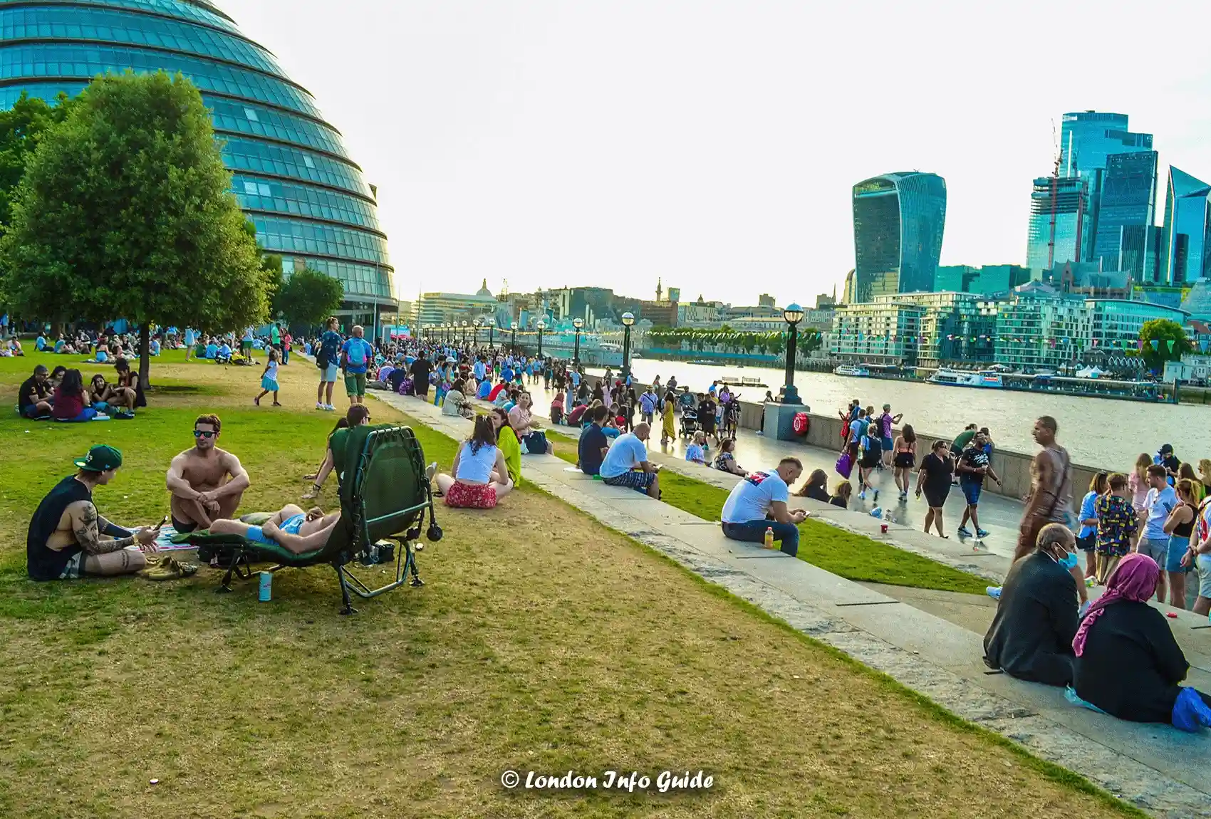 The Garden Beside The Queen's Walk Next To Tower Bridge On A Hot Day When Lots Of People Are Taking Advantage Of The Lovely Weather. The Garden Beside The Queen's Walk near Tower Bridge.
the open garden besides The Queen's Walk Adjacent to Tower Bridge.