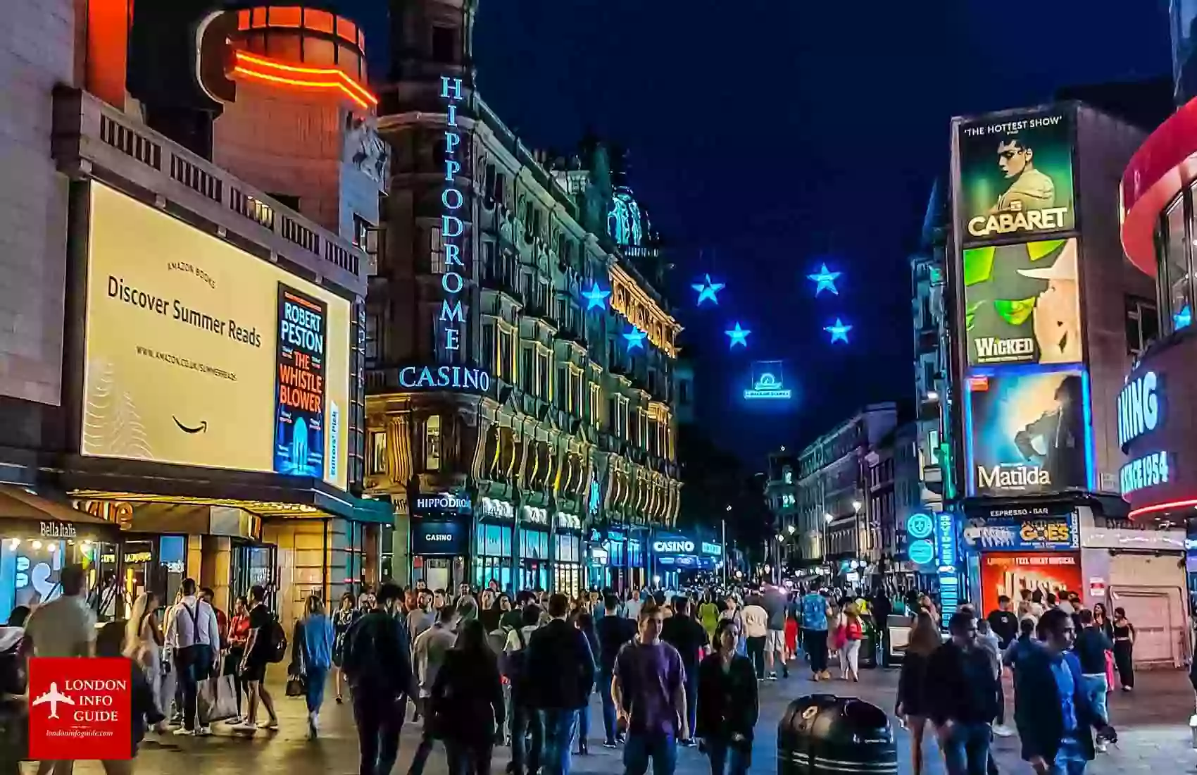 People walking through the streets of Piccadilly Circus London at night during the weekend. Piccadilly Circus in London at night
