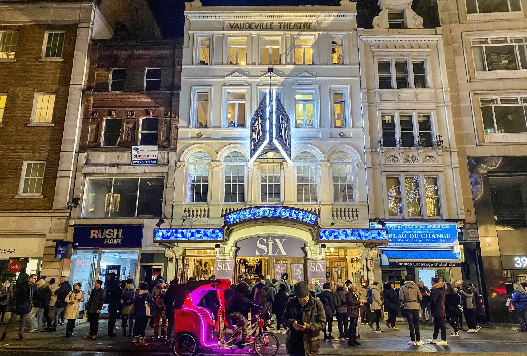 Vaudeville Theatre in London UK with 'Six' musical signage at night.