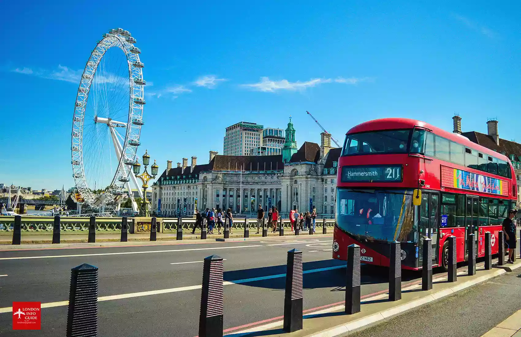 A red London double decker bus driving over Westminster Bridge in London with a view of the London Eye at South Bank London. South Bank London UK.