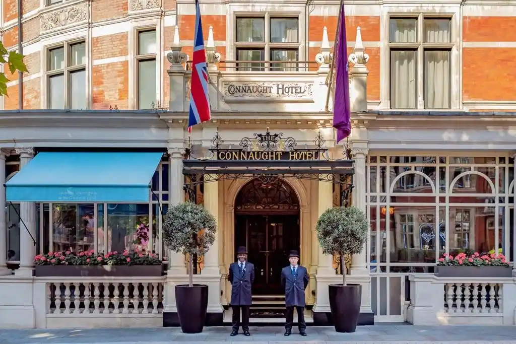 Elegant entrance of The Connaught Hotel London UK with staff standing outside.