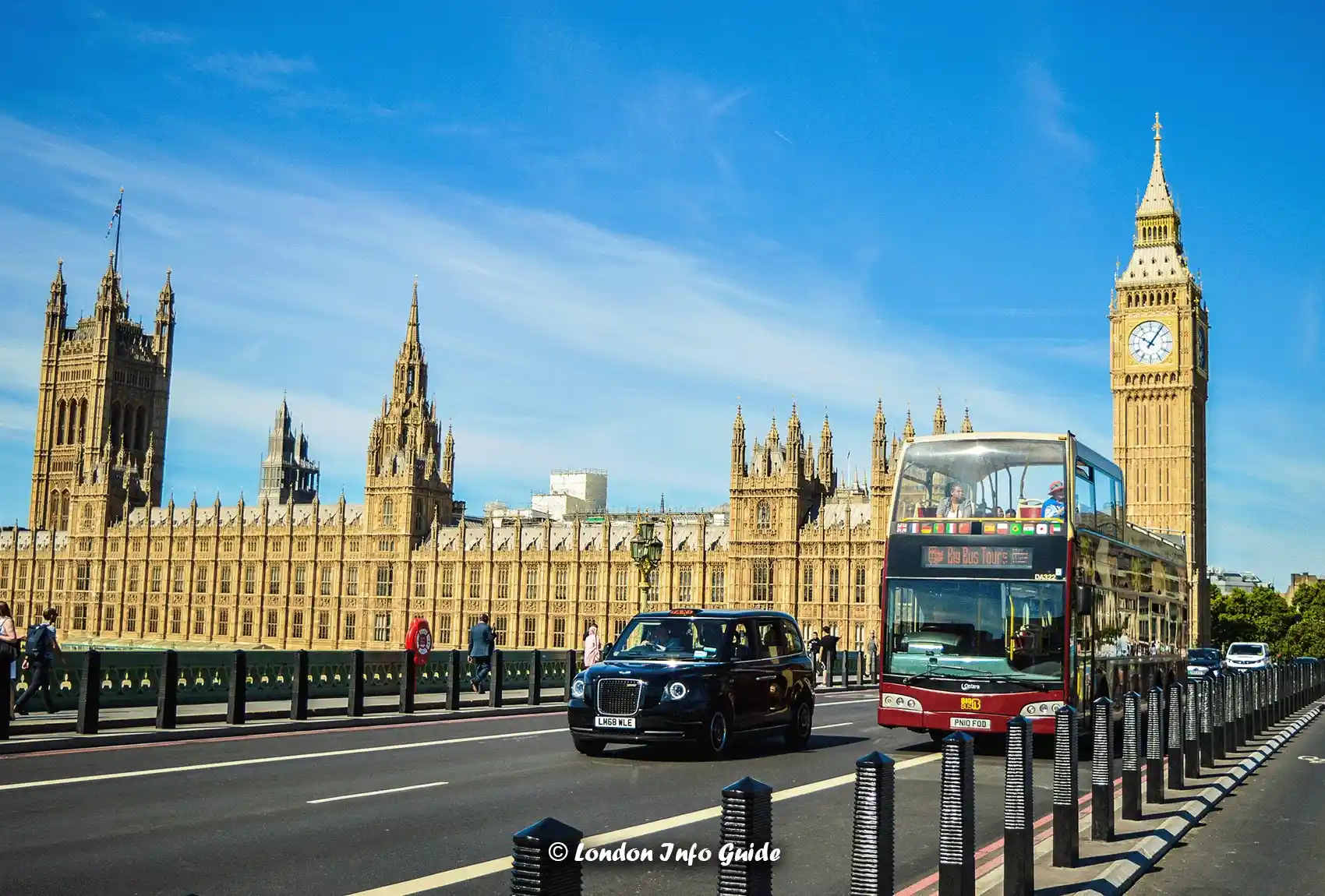 A black taxi and sightseeing bus driving across Westminster Bridge London With Big Ben in the Background. Westminster Bridge London With Big Ben in the Background.