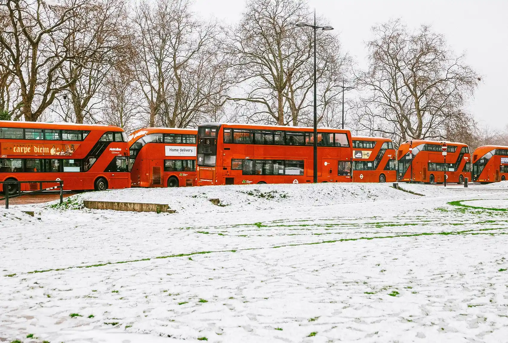 London red buses parked on a snowy December morning. London red buses in the snow.
